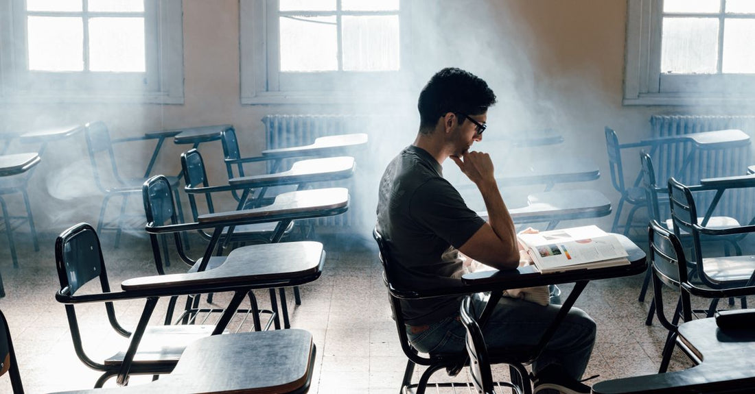 Calm student studying at a desk with coffee pushed aside